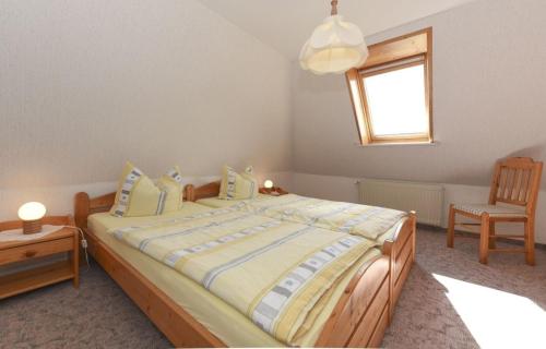 ニーブルムにあるGeestblick Whg 01 OG liのベッドルーム1室(ベッド1台、椅子、窓付)