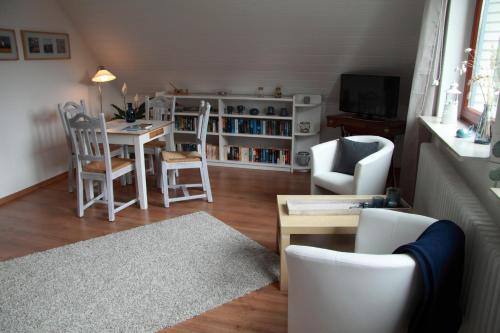 ein Wohnzimmer mit einem Tisch und Stühlen in der Unterkunft Ferienwohnung weißes Haus in Meeschendorf