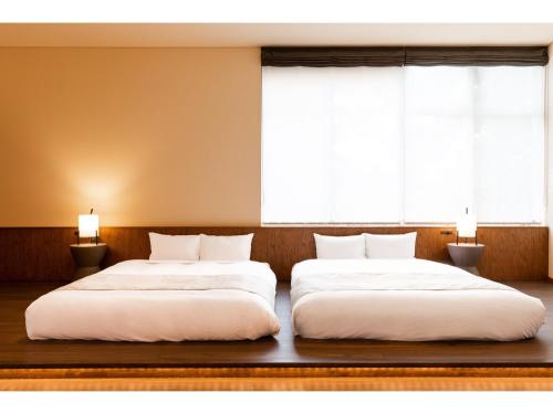軽井沢町にあるHOTEL KARUIZAWA CROSS - Vacation STAY 56422vの窓が2つある部屋にベッドが2つある