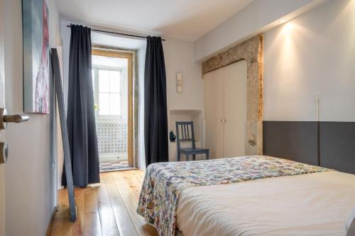 sypialnia z łóżkiem i oknem w obiekcie Lisbon Heart Apartments - Blue Apartment by LovelyStay w Lizbonie