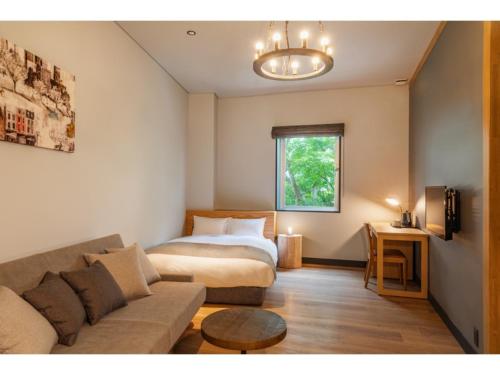 a living room with a couch and a bed at HOTEL KARUIZAWA CROSS - Vacation STAY 56455v in Karuizawa