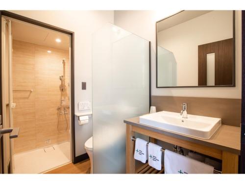 a bathroom with a sink and a toilet and a mirror at HOTEL KARUIZAWA CROSS - Vacation STAY 56455v in Karuizawa