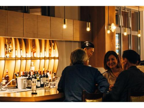 a group of people sitting at a bar at HOTEL KARUIZAWA CROSS - Vacation STAY 56455v in Karuizawa