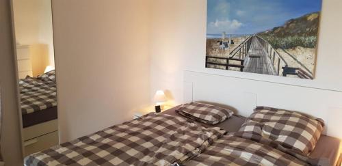 a bedroom with a bed and a picture of a bridge at Schünke, FP, I-3-6 in Heiligenhafen