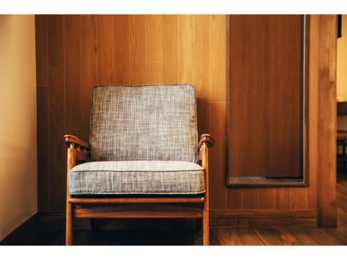 a chair in a room with a wooden wall at HOTEL KARUIZAWA CROSS - Vacation STAY 56467v in Karuizawa