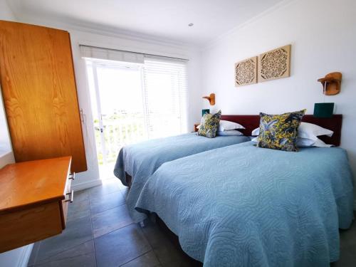a bedroom with two beds and a window at Bellamente Sirene in Gansbaai