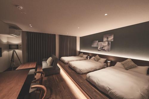 松戸市にあるReLA Higashimatsudo - Vacation STAY 67557vのベッド2台とソファが備わるホテルルームです。