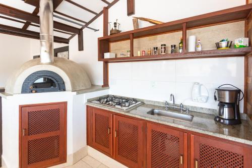 a kitchen with a stove and an oven at Bliss Hotel Vale do Café in Vassouras