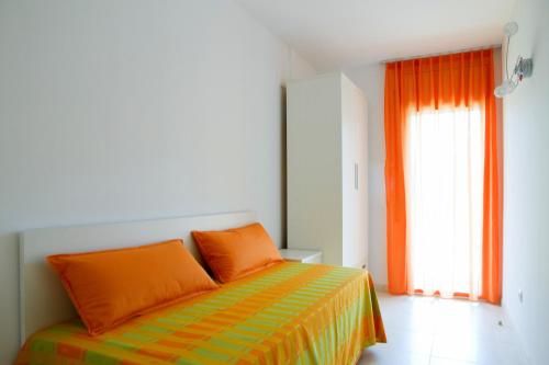 a bedroom with a bed with orange pillows and a window at Rentalmar Paradise Families Only con parking in Salou