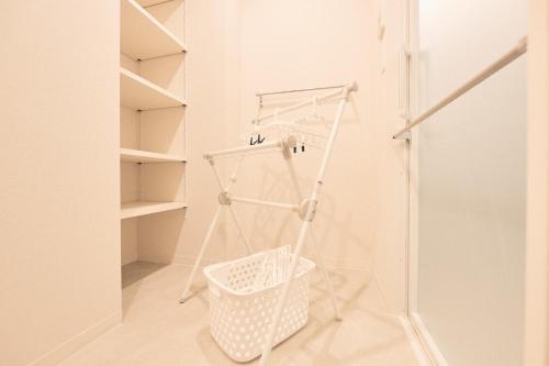 a white laundry room with a basket on the floor at ReLA Higashimatsudo - Vacation STAY 66379v in Matsudo