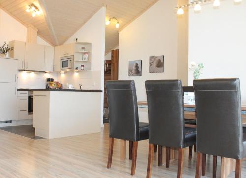 eine Küche und ein Esszimmer mit einem Tisch und Stühlen in der Unterkunft "Ferienhaus II - Hof Westensee" in Grömitz