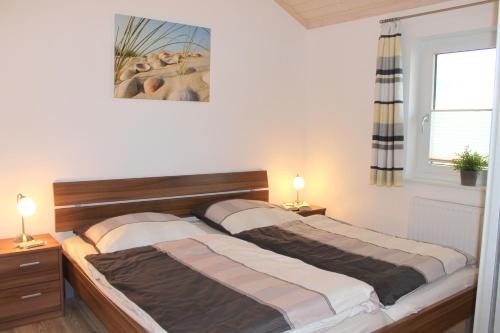 グレーミッツにある"Ferienhaus II - Hof Westensee"のベッドルーム1室(ベッド2台、窓、ランプ2つ付)