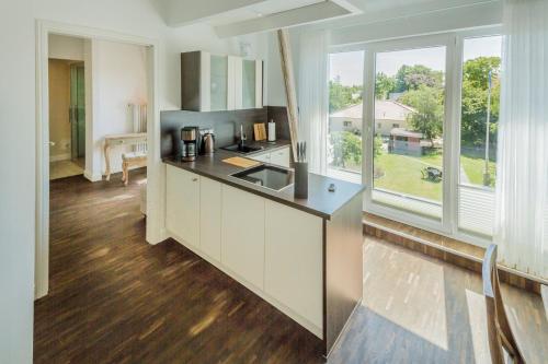a kitchen with white cabinets and a large window at "Villa Anker" 1 Etage - links in Fehmarn