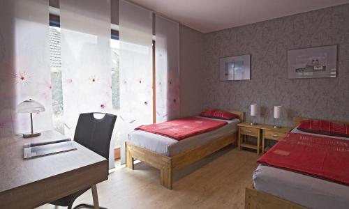 1 Schlafzimmer mit 2 Betten, einem Schreibtisch und einem Fenster in der Unterkunft Haus Birkenweg in Westerrönfeld