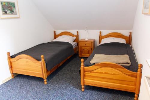 2 Einzelbetten in einem Schlafzimmer mit einem Nachttisch in der Unterkunft Knipper RE24 in Sögel