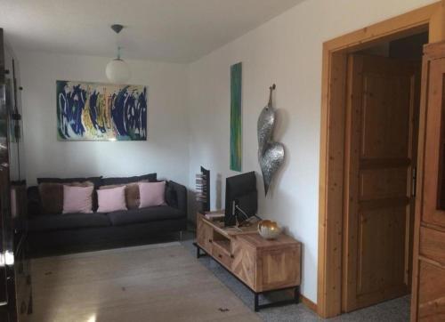ein Wohnzimmer mit einem Sofa und einem Tisch in der Unterkunft Braunkehlchen in Straubenhardt
