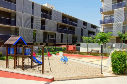 a playground in front of a apartment building at Rentalmar Paradise Families Only con parking in Salou