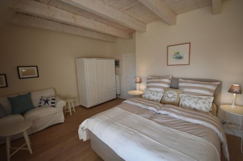 a bedroom with a large bed and a couch at Hoheluft am Wittensee Apt 3 in Groß Wittensee