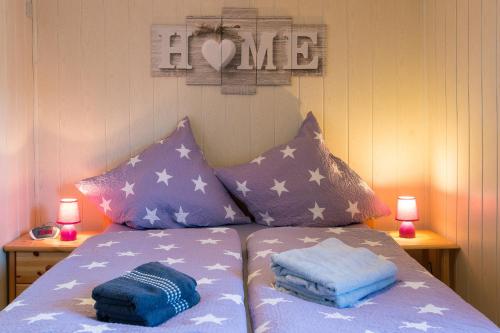 エッカーンフェルデにあるDaniel-Ferienhaus 2のベッド(紫と白の枕付)