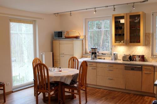 a kitchen with a table and a table and chairs at Strandvilla Sophie App 2 in Dierhagen