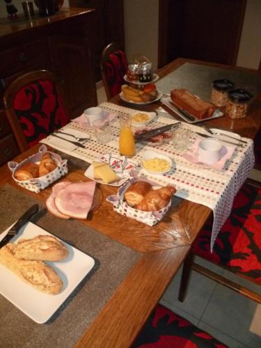 een tafel met brood en ander voedsel erop bij Au repos de la licorne in Gommegnies