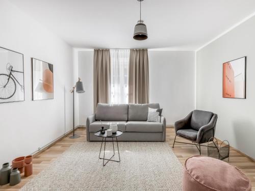 a living room with a couch and a chair at Limehome Villach Kirchenplatz in Villach