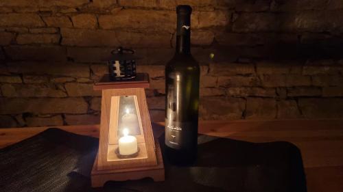 a bottle of wine and a candle next to a wall at Chaloupka Rozkoš in Nové Město nad Metují