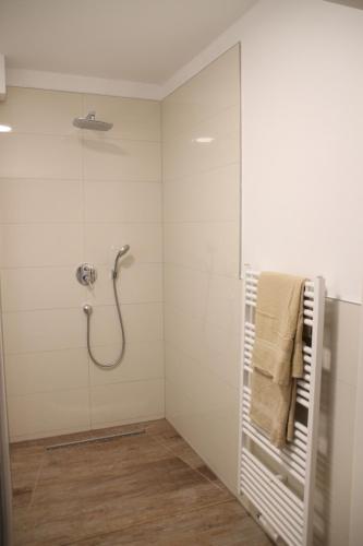 a bathroom with a shower and a towel rack at Casa Kronengarten Nr 5 in Hilden