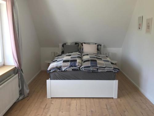 a bed in a small room with a white bed frame at Nordische Ferienwohnung auf Gut Bennewohld LL in Heide