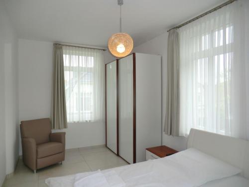 1 dormitorio con 1 cama y 1 silla en Strandkorb - Whg 4, en Wyk auf Föhr