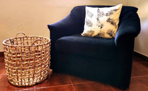 a blue chair with a pillow and a basket at D'Oliva Gerês - River Side Houses in Geres