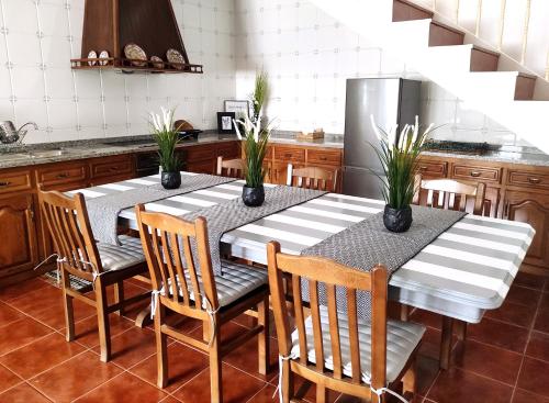 a kitchen with a table with chairs and a refrigerator at D'Oliva Gerês - River Side Houses in Geres