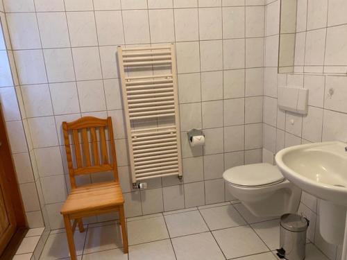 ハイリゲンハーフェンにあるFischerhäuschen Achterstraßeのバスルーム(トイレ、シンク、椅子付)