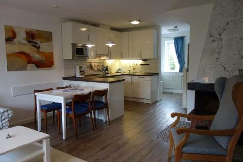 a kitchen and living room with a table and chairs at Pastoratshof - Whg2 in Wrixum