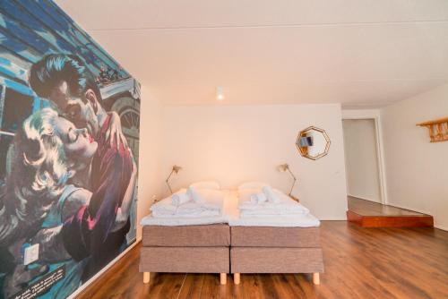 a bed in a room with a large painting on the wall at Pink Flamingo Boutique Hostel in The Hague