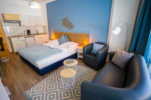um quarto de hotel com uma cama e duas cadeiras em Studio 12 "Fischschwarm" em Grömitz