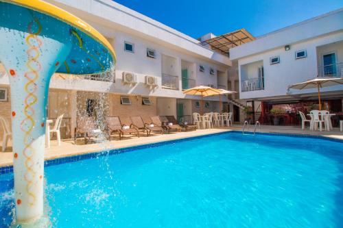 a pool with a water slide in front of a building at Shangrilá - Rede Soberano in Porto Seguro