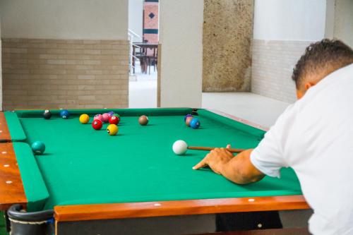 a man playing pool on a pool table at Shangrilá - Rede Soberano in Porto Seguro