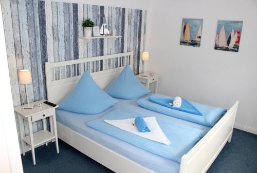 a bedroom with a bed with blue pillows on it at LANDHAUS AM HAFEN im EG in Heiligenhafen