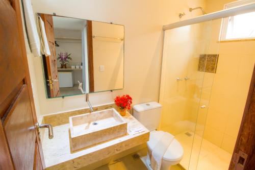a bathroom with a sink and a toilet and a shower at Shangrilá - Rede Soberano in Porto Seguro