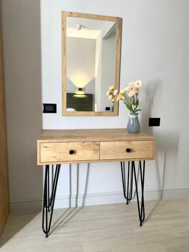 a table with a mirror and a vase with flowers on it at Апарт-отель Nine Rooms in Yerevan