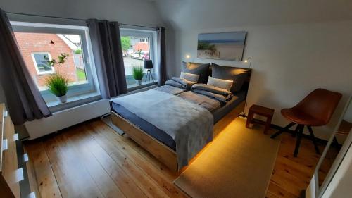 布雷茨特的住宿－De Lüdde Mangelstuv，一间卧室设有一张大床和两个窗户。