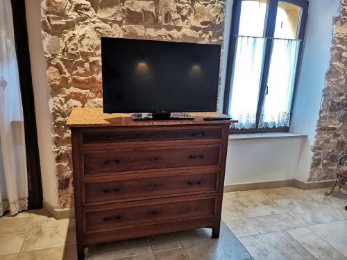 una televisione in cima a un comò in una stanza di b&b da Alberto ad Arcevia