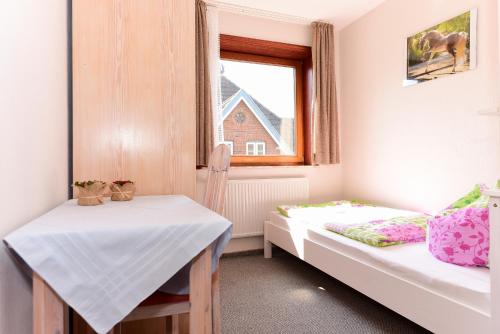 ニーブルムにあるSchleswig-Holstein Whg 03 OG liのベッド2台と窓が備わる小さな客室です。
