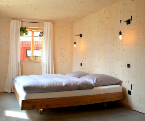 1 dormitorio con 1 cama en una habitación con ventana en Architektenhaus Reischl mit Sauna, en Neubeuern