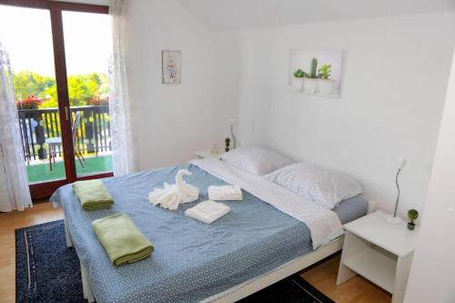 Merak Holiday Home في فيسوكو: غرفة نوم عليها سرير وفوط