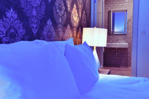 a bedroom with a bed with a lamp and a sink at Xeuchia Accommodation in Xewkija