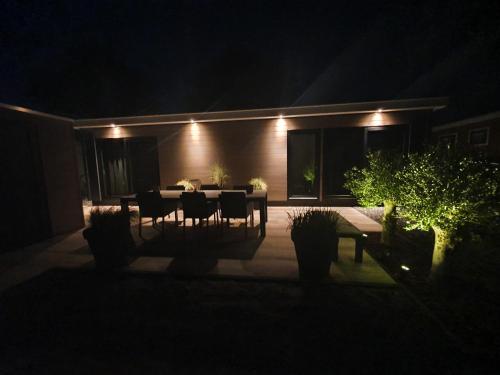 a patio with a table and chairs at night at Beachhouse Renesse 2645 in Renesse