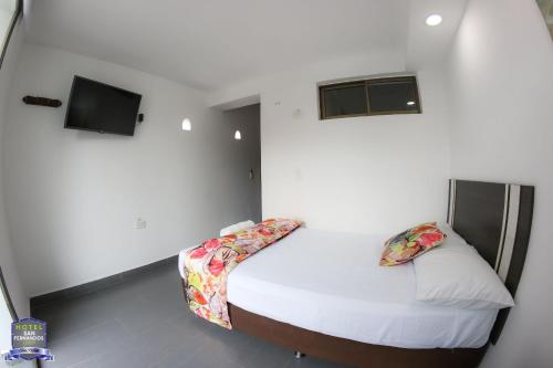 a small bedroom with a bed and a tv at Hotel San Fernandos Plaza in San Rafael
