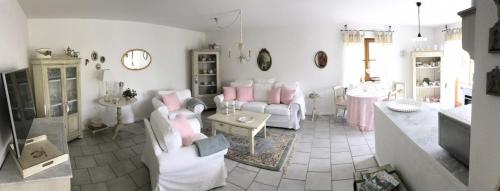 sala de estar con muebles blancos y almohadas rosas en Ferienwohnung Lau, en Steingaden